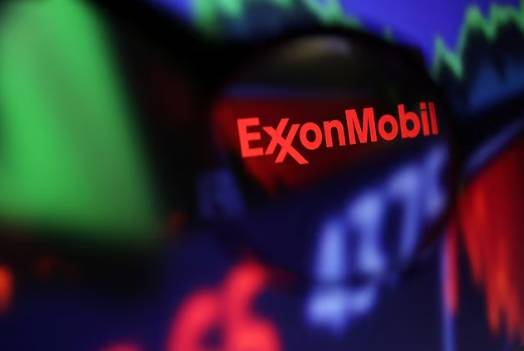 Exxon Mobil logo and stock graph are seen through a magnifier displayed in this illustration taken September 4, 2022.