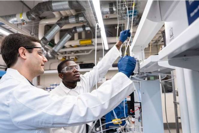 在催化研究中,研究人员需要仔细控制催化材料所处的环境,以免其中毒或催化不良的副反应。图中,弗吉尼亚大学化学工程助理教授 Jason Bates(左)和博士生 Isaac Boateng 讨论了与电化学反应器系统接口的气体配置