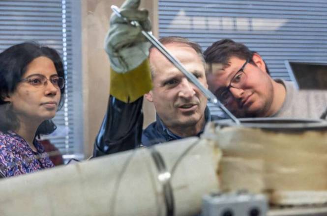 从左至右依次为:首席研究员Ruchi Gakhar、技术员Dean Burt和实习生Diego Macias,他们正在往循环系统中装盐