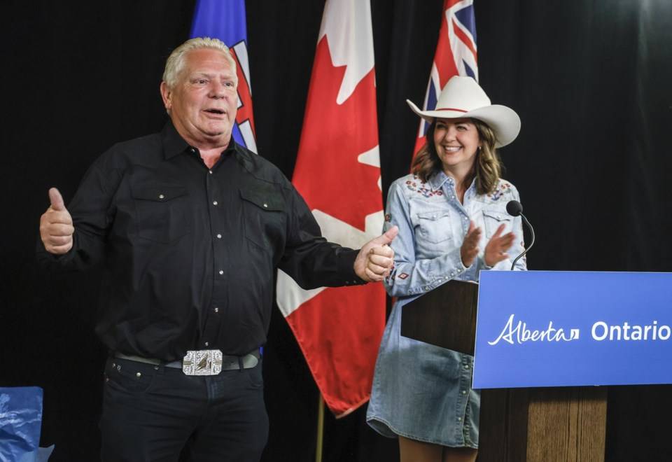 2025 年 7 月 7 日星期一，安大略省省长道格&middot;福特 (Doug Ford)（左）在阿尔伯塔省卡尔加里签署建设新能源和贸易基础设施的协议后，展示阿尔伯塔省省长丹妮尔&middot;史密斯赠送给他的新皮带扣。加拿大通讯社/杰夫&middot;麦金托什