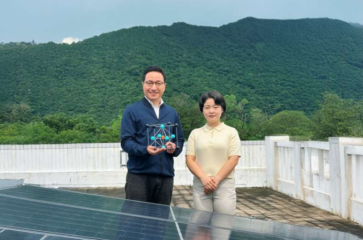 通讯作者周媛媛教授(左)手持钙钛矿晶体模型,第一作者段天伟博士(右)站在太阳能电池板前。图片来源:香港科技大学