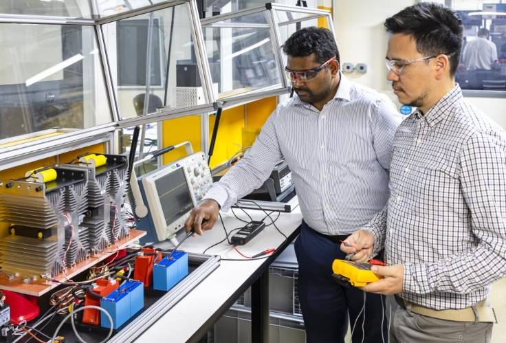 美国能源部橡树岭国家实验室(ORNL)的研究人员正致力于研发速度更快的中压断路器,以支持并保护现代电网,特别是推动直流电在电网中的广泛应用。 首席研究员普拉萨德·坎杜拉指出,缺乏直流中压断路器一直是电力输送灵活性的一大障碍。新研发的中压断路器能够以更低的成本处理更高水平的直流电,有助于降低电力成本,并扩大美国电网的容量。 断路器是电网中的关键安全装置,能在电流异常或系统故障时自动切断电流,防止火灾或断电风险。传统的断路器适用于交流电,但直流电因其单向流动特性,难以被传统机械开关快速切断。ORNL的研究人员正在设计并扩大一种新型半导体断路器的容量,其操作速度比机械开关快一百倍,使得直流电在电网中的应用更加广泛。 直流系统因其效率、灵活性和与现代能源及负载的兼容性,对能源系统设计师更具吸引力。它能为能源密集型项目如人工智能数据中心提供更经济的电力,减少传输过程中的能量损失。中压断路器对于实现直流配电至关重要,半导体断路器为直流系统提供了速度和更高的安全性,显著降低了安全性和野火风险。 然而,半导体断路器此前因价格过高,无法与交流电的机械断路器竞争,也限制了直流电网的扩大使用。ORNL团队选择了一种经济高效的半导体——晶闸管,并设计了一个外部电路来强制降低电流。他们在电网研究创新与发展中心构建并测试了一个断路器原型,该原型能在不到50微秒的时间内切断1400伏的电流,速度比之前演示的晶闸管快了四到六倍。 为证明该技术可扩展到处理更高电压,研究人员将断路器串联起来,并设计了解决方案以应对电压分配和快速反应时间等挑战。他们在一系列高达1800伏的断路器中进行了测试,并正努力将电压提升至10000伏,以满足未来直流电网更大的能源需求。 该项目是ORNL更大规模计划的一部分,旨在开发一系列可堆叠的中压模块,以扩展美国交通运输、制造业和数据中心的新型电力应用。该项目由美国能源部电力办公室资助,其他参与研究人员包括Marcio Kimpara和Elvey Andrade。