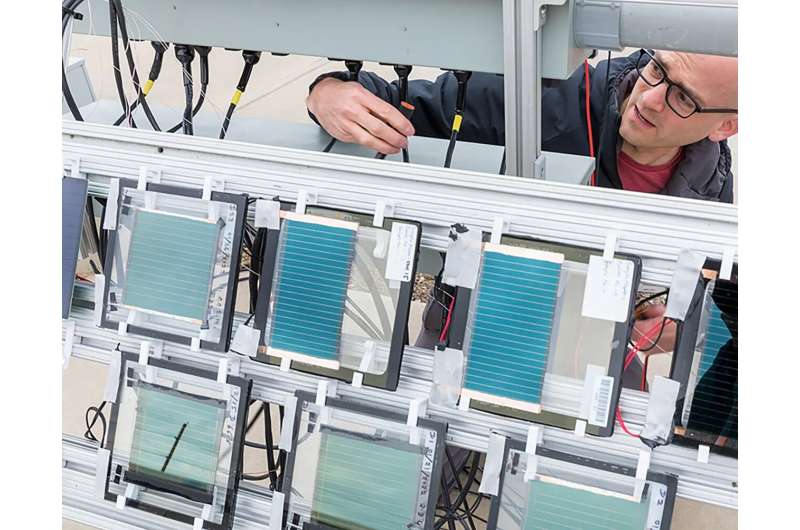 NREL高级科学家Tim Silverman在实验室的户外测试设施中安装一块小型钙钛矿太阳能电池板。图片来源:Werner Slocum,NREL