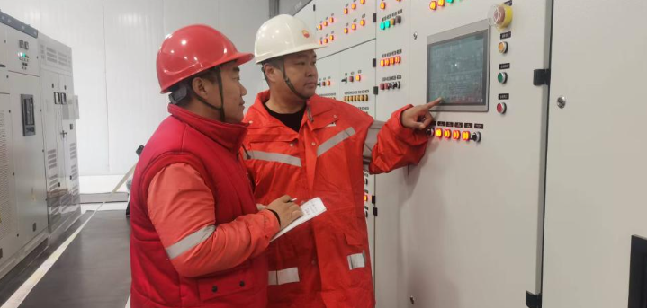 10月10日，李冬(右)和同事在检查设备运行参数。